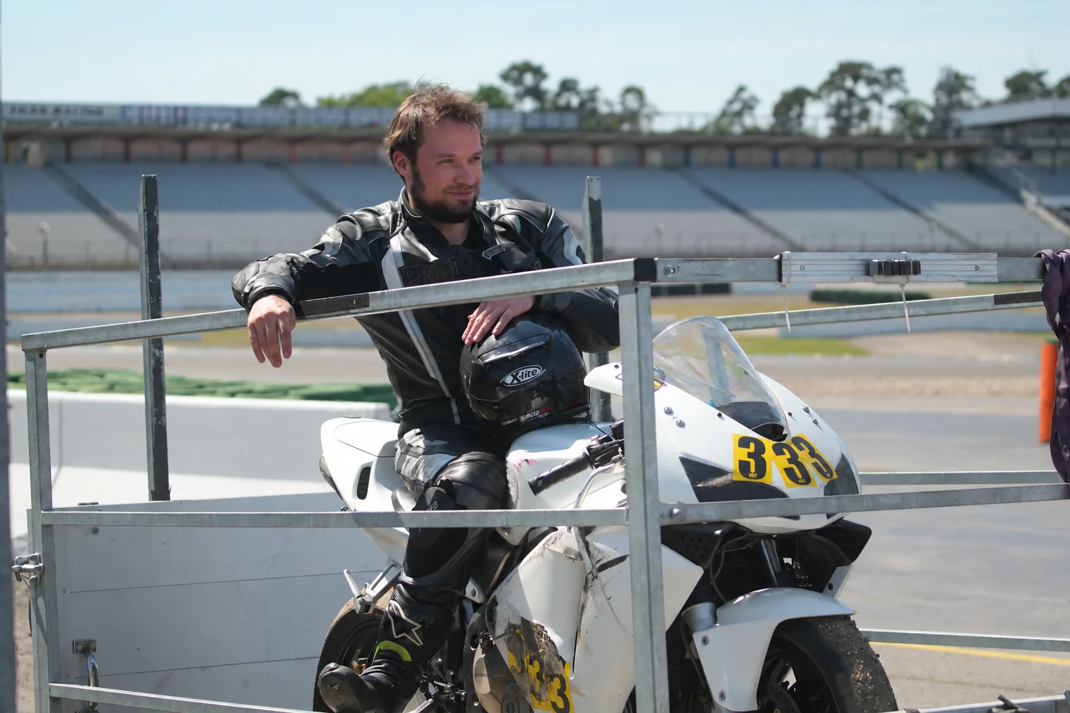 Motorcycle racer sitting on a bike in the paddock