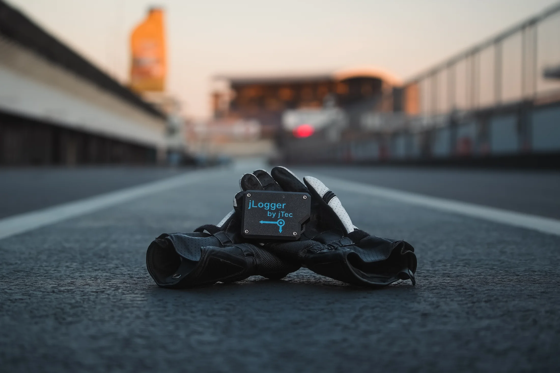 jLogger resting on racing gloves in the pit lane